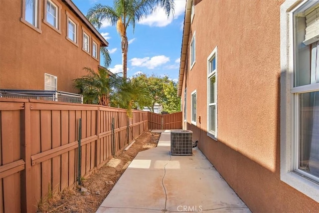 view of side of home featuring a patio and central AC