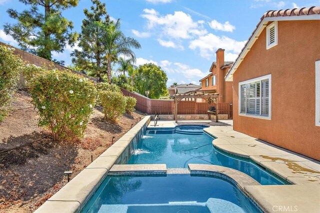 view of swimming pool with an in ground hot tub