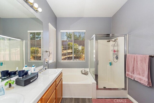 bathroom with wood-type flooring, vanity, independent shower and bath, and a healthy amount of sunlight