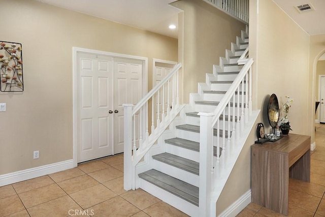 staircase featuring tile patterned flooring