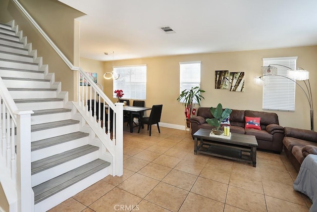 living room featuring light tile patterned floors and an inviting chandelier