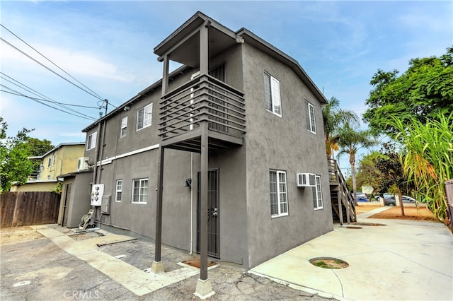 rear view of house with a patio and a balcony