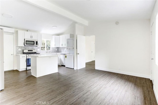kitchen with stainless steel appliances, lofted ceiling with beams, open floor plan, white cabinetry, and backsplash
