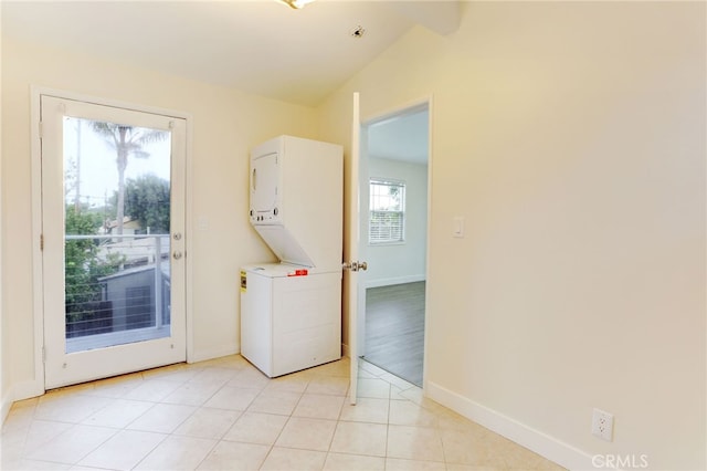 washroom featuring stacked washer / dryer and light tile patterned floors