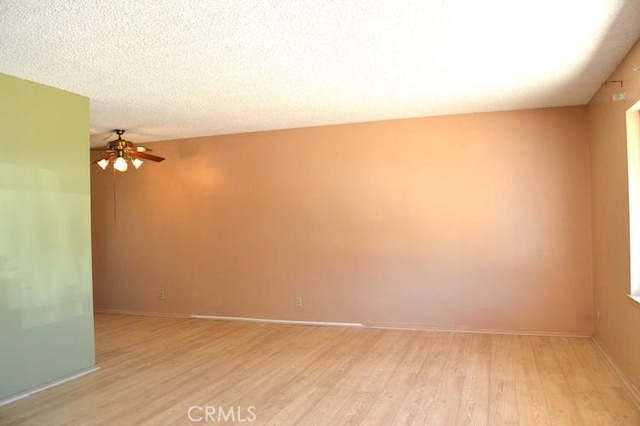 empty room featuring light hardwood / wood-style floors, a textured ceiling, and ceiling fan