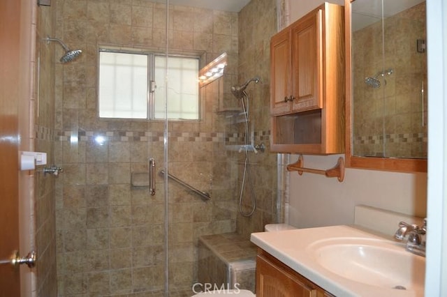 bathroom with vanity, an enclosed shower, and toilet