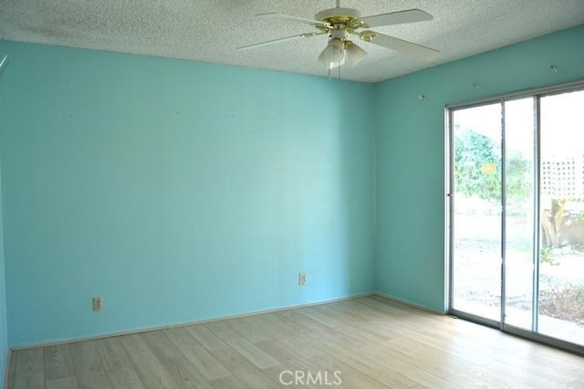 empty room with a textured ceiling, light hardwood / wood-style floors, and ceiling fan