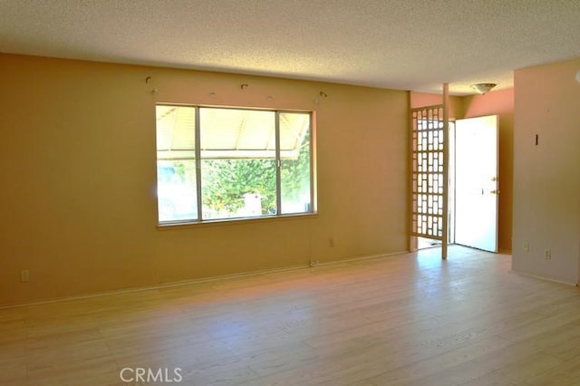 empty room featuring light hardwood / wood-style floors and a textured ceiling