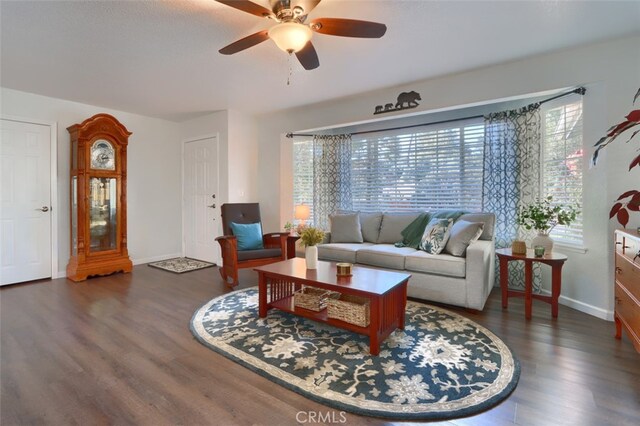 living room with dark wood-type flooring and ceiling fan