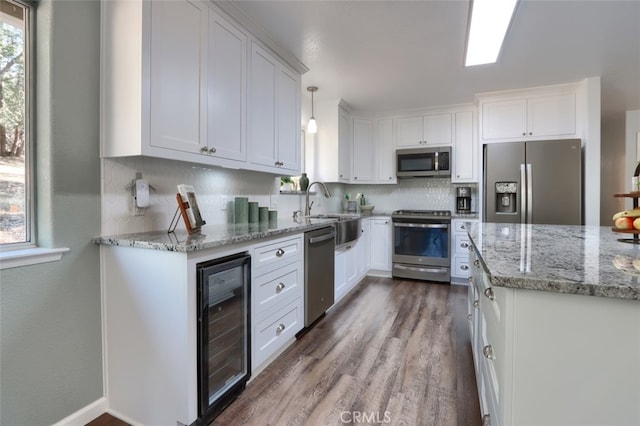 kitchen with wine cooler, dark hardwood / wood-style flooring, appliances with stainless steel finishes, white cabinetry, and decorative light fixtures