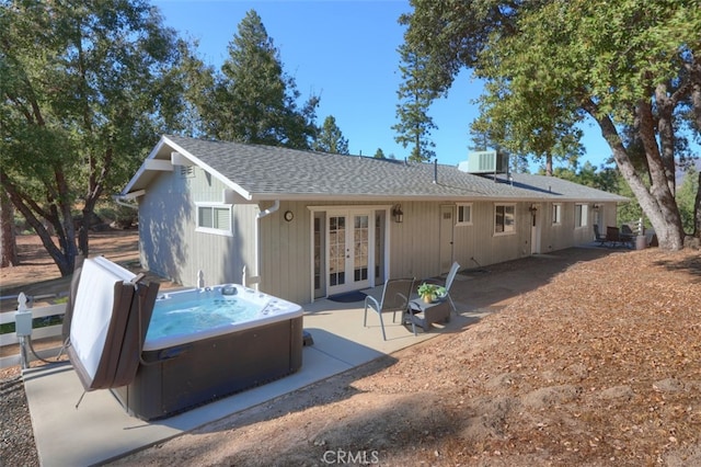 back of property with a hot tub, french doors, and a patio