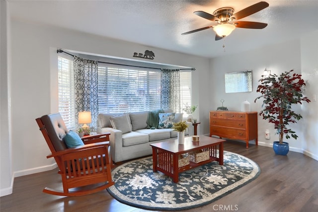 living room with ceiling fan, a textured ceiling, and dark hardwood / wood-style flooring