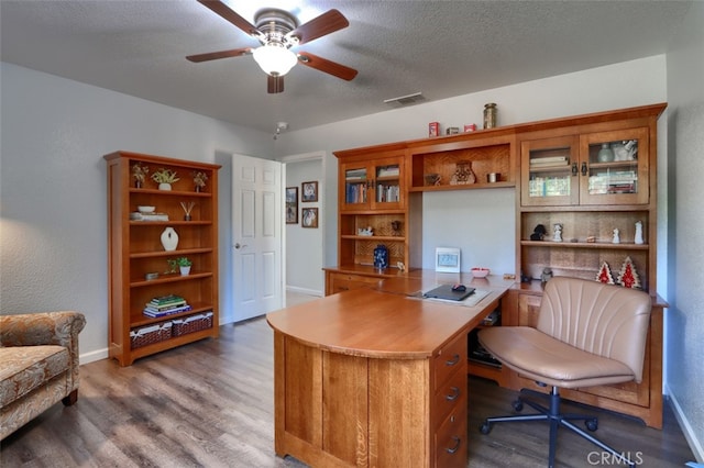 office area featuring dark wood-type flooring, ceiling fan, and a textured ceiling