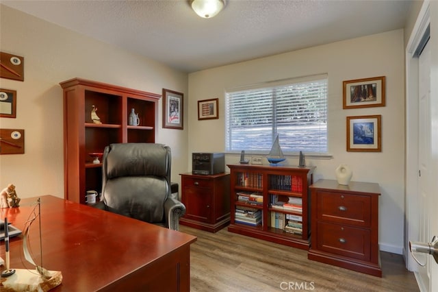 office space featuring a textured ceiling and light hardwood / wood-style floors