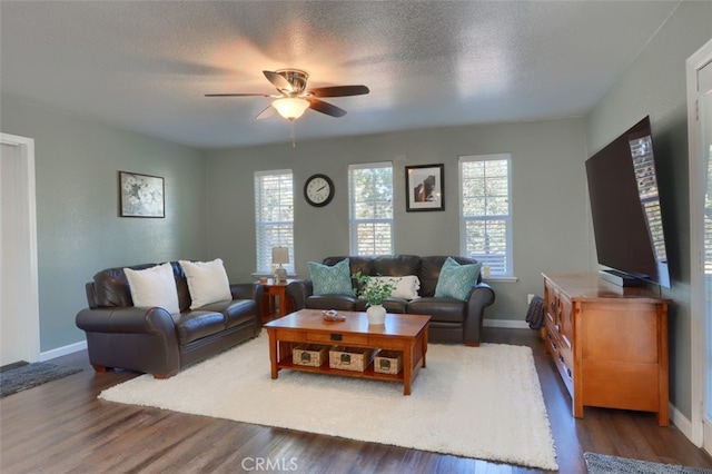 living room featuring a textured ceiling, ceiling fan, and dark hardwood / wood-style flooring