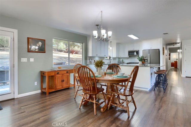 dining area featuring dark wood-type flooring, a notable chandelier, and a wealth of natural light