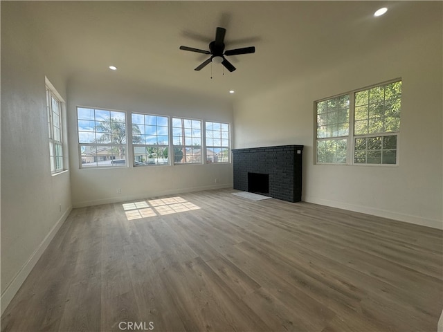 unfurnished living room featuring a fireplace, hardwood / wood-style flooring, and ceiling fan