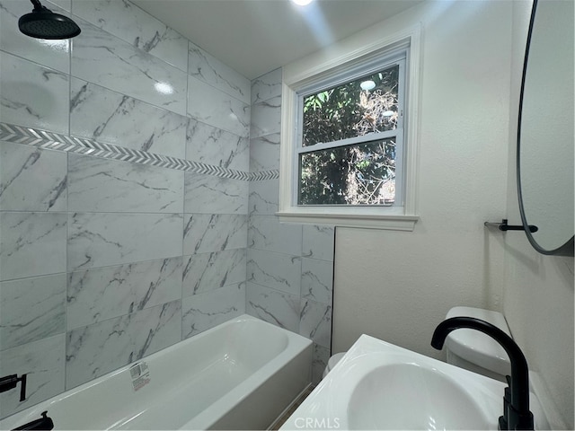 bathroom featuring vanity and tiled shower / bath