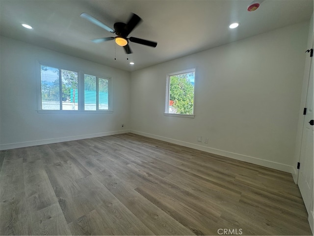 empty room with hardwood / wood-style flooring and ceiling fan