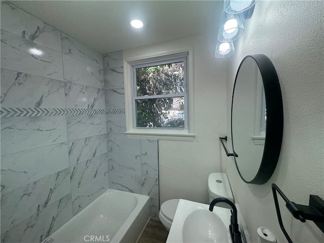 bathroom with toilet and tiled shower / bath