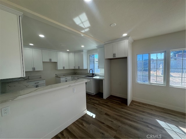 kitchen featuring a wealth of natural light, white cabinetry, and dark hardwood / wood-style floors