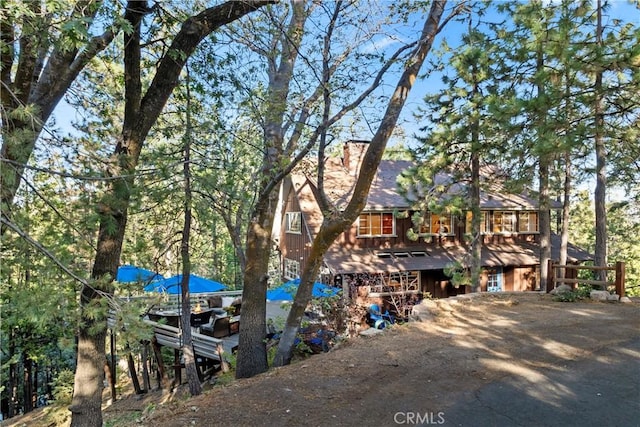 309 Castle Gate Rd, Lake Arrowhead, CA 92352 - view of front of house with dirt driveway and a chimney