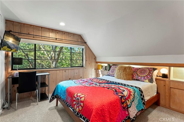 bedroom featuring wood walls, light colored carpet, and lofted ceiling