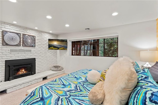 carpeted bedroom with a brick fireplace