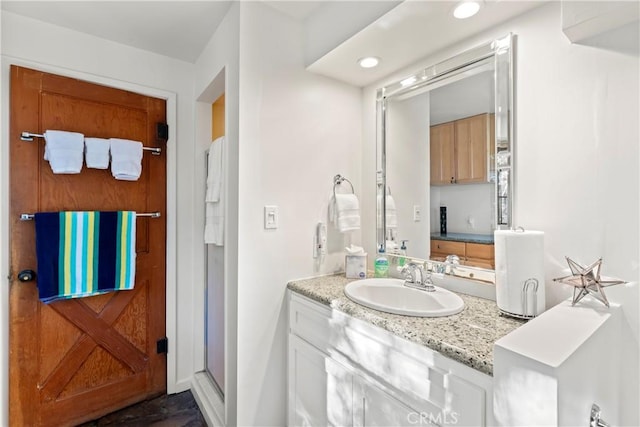 bathroom with vanity and a shower with shower door