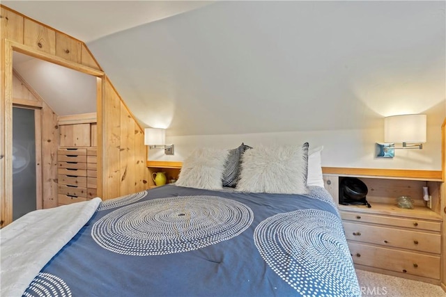 carpeted bedroom with lofted ceiling and wood walls