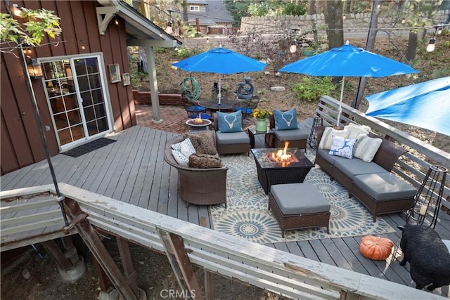 deck with an outdoor living space with a fire pit