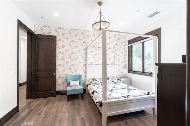 bedroom featuring visible vents, wood finished floors, baseboards, wallpapered walls, and recessed lighting