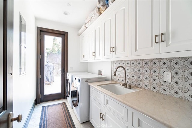 clothes washing area featuring cabinets, independent washer and dryer, and sink