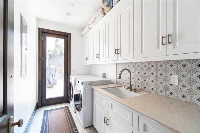 laundry area with separate washer and dryer, a sink, and cabinet space