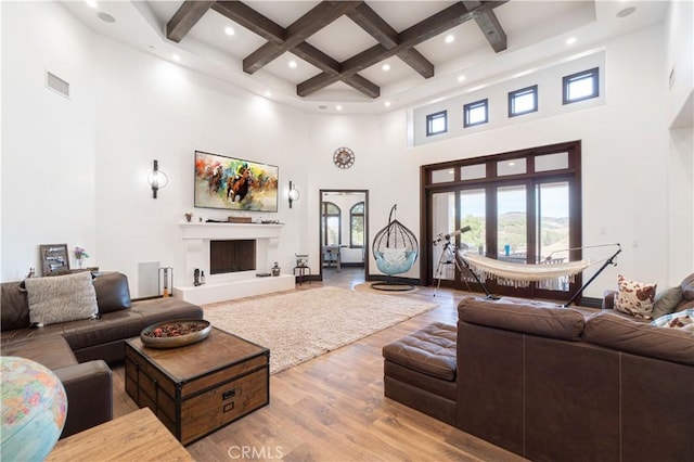 living room featuring visible vents, a towering ceiling, wood finished floors, beamed ceiling, and coffered ceiling