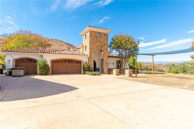 mediterranean / spanish-style house featuring a garage, a tiled roof, driveway, and stucco siding