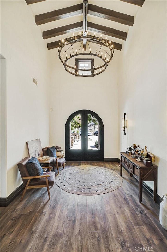 foyer entrance featuring an inviting chandelier, wood finished floors, beamed ceiling, high vaulted ceiling, and french doors