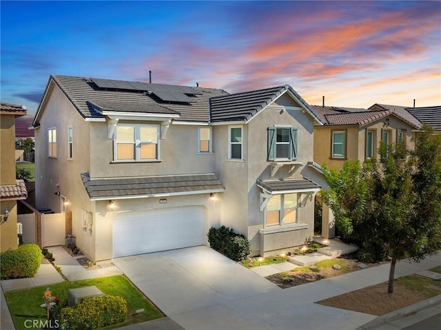 view of front of property featuring solar panels and a garage