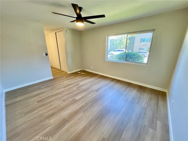 empty room with ceiling fan and light wood-type flooring