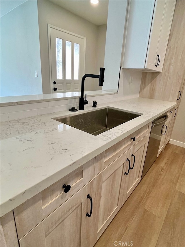 kitchen featuring light hardwood / wood-style flooring, light brown cabinets, light stone countertops, and sink