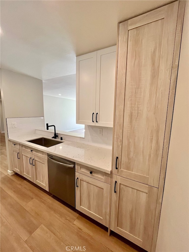 kitchen with dishwasher, decorative backsplash, sink, light wood-type flooring, and light stone counters