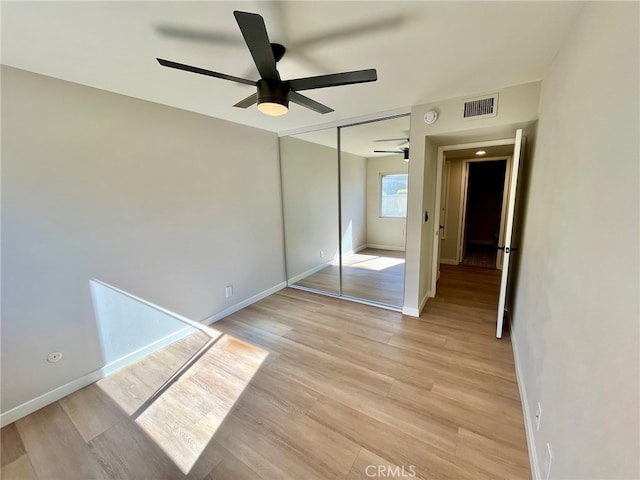 unfurnished bedroom with a closet, ceiling fan, and light wood-type flooring