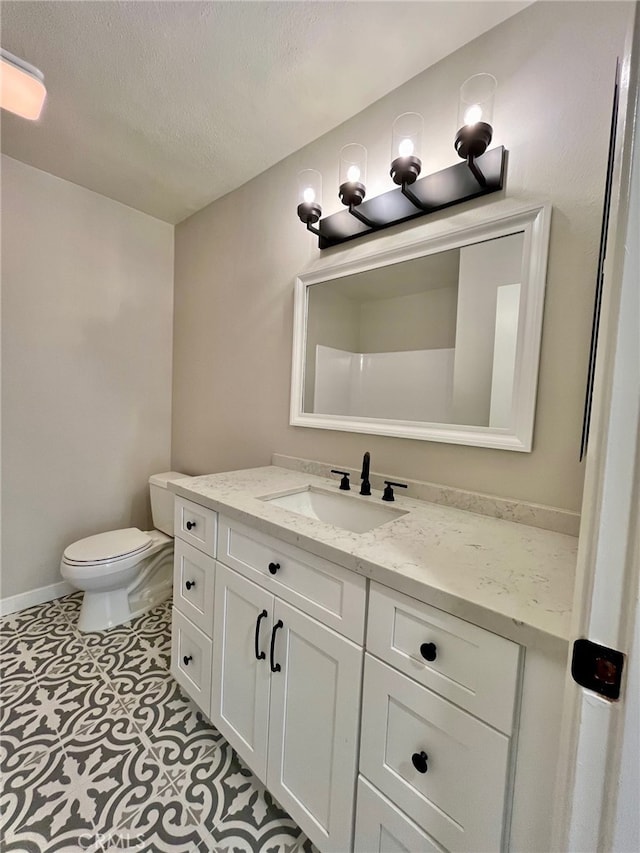 bathroom featuring vanity, a textured ceiling, toilet, and tile patterned floors