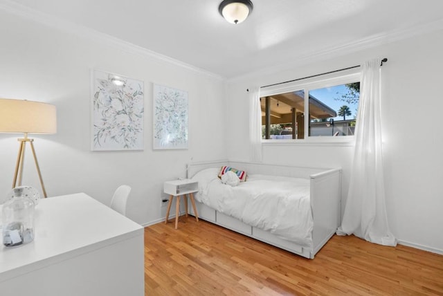 bedroom featuring crown molding and light wood-type flooring