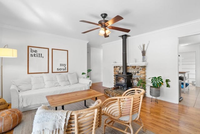 living room featuring ornamental molding, wood-type flooring, and a wood stove