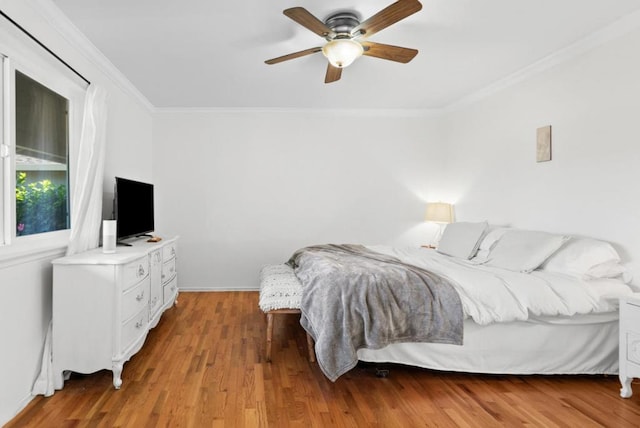 bedroom featuring hardwood / wood-style floors, ornamental molding, and ceiling fan