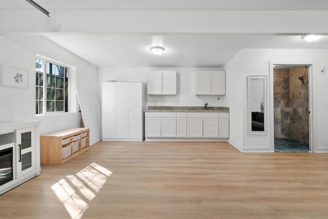 kitchen with sink, light hardwood / wood-style flooring, and white cabinets