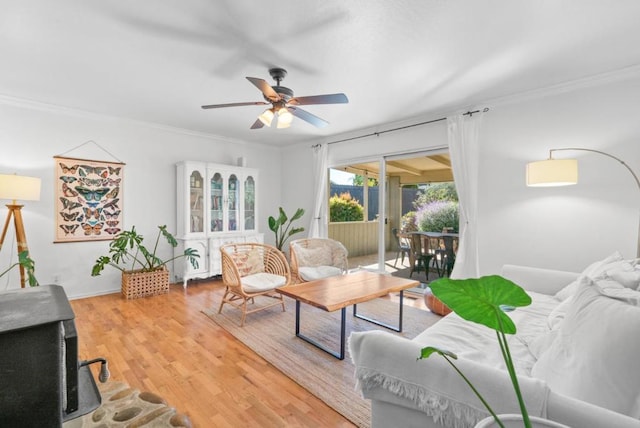 living room with hardwood / wood-style flooring, ceiling fan, and crown molding