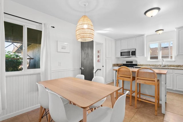 dining area featuring sink and light tile patterned floors