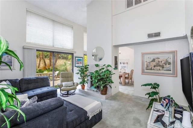 living room with light carpet and a high ceiling